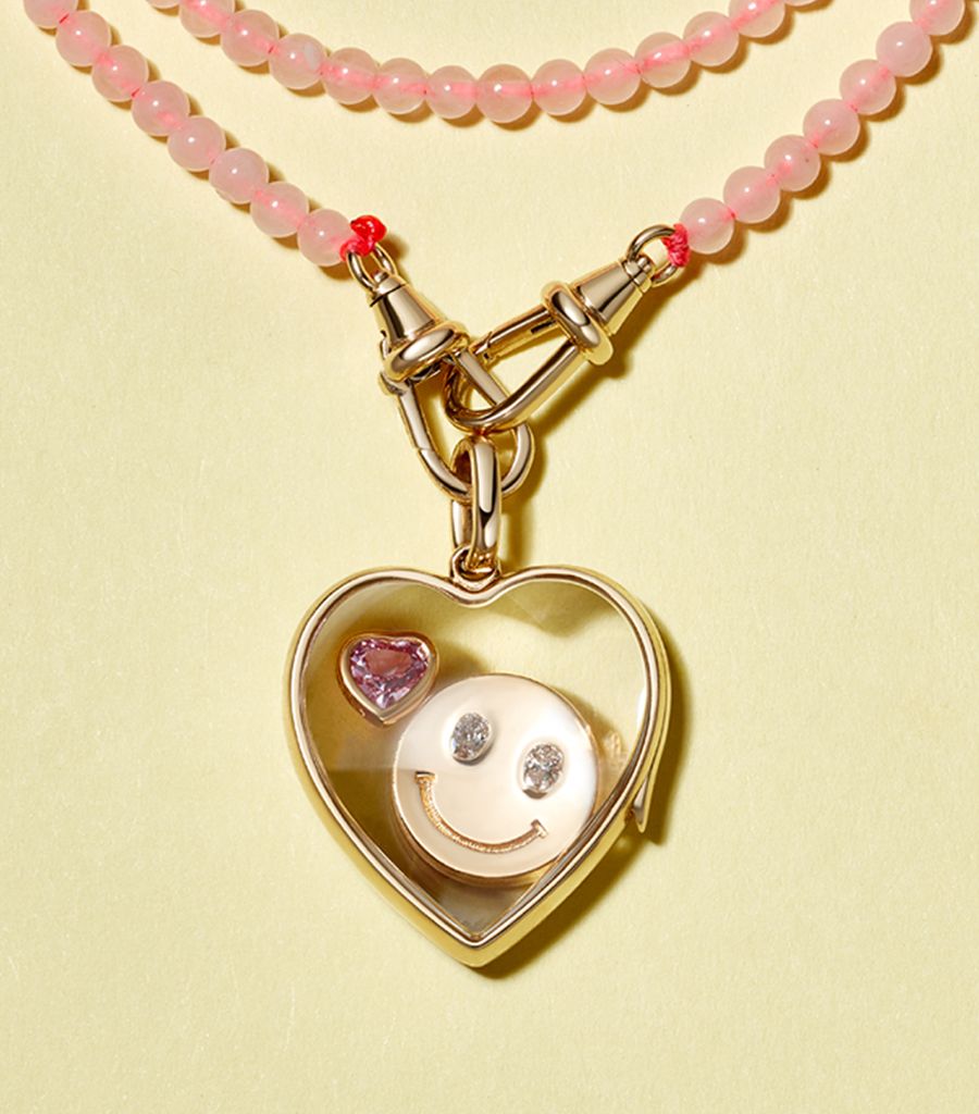 pre-made heart locket pendant styled with a rose quartz beaded chain and a pink sapphire heart charm and a smiley charm 
