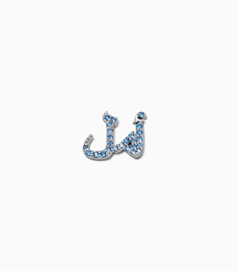 Arabic script for Hope charm in 18k white gold set with pale blue sapphires and blue enamel designed by Loquet London