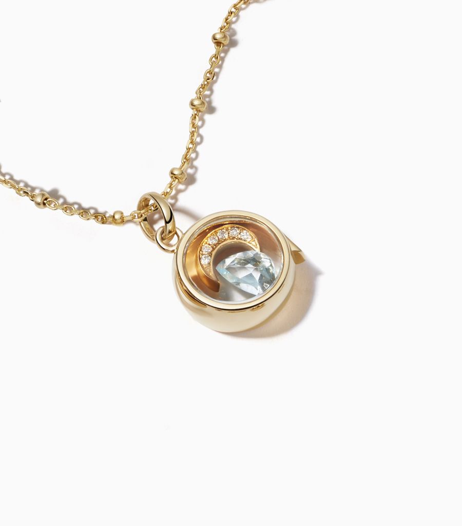 9 carat yellow gold, round locket, set with a bevel edged, crystal glass front and a flat crystal glass back. The locket is designed with a side hindge for secure fastening and measures 12mm